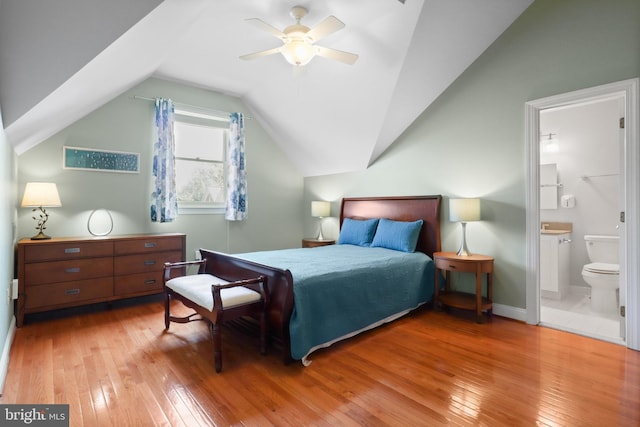 bedroom with ensuite bathroom, ceiling fan, vaulted ceiling, and hardwood / wood-style flooring