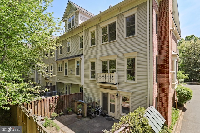rear view of property featuring a patio and fence