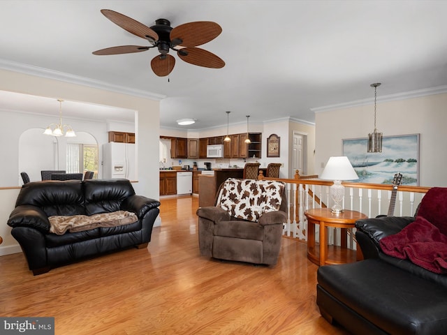 living room with ceiling fan with notable chandelier, light wood-style floors, and crown molding