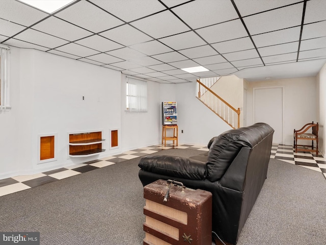 carpeted living room featuring stairway and a drop ceiling