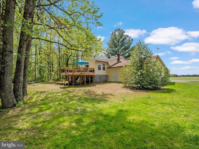 back of property featuring stairway, a deck, a yard, and a chimney