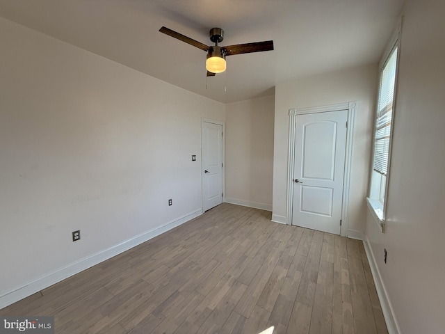 unfurnished room featuring baseboards, a ceiling fan, and wood finished floors