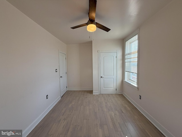 unfurnished bedroom with baseboards, a ceiling fan, and wood finished floors