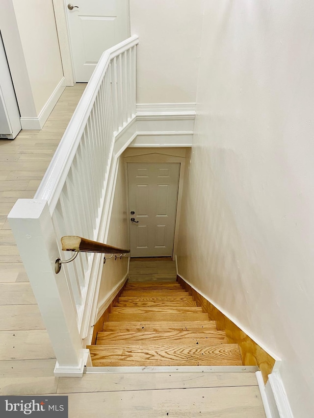 stairway with baseboards and wood-type flooring