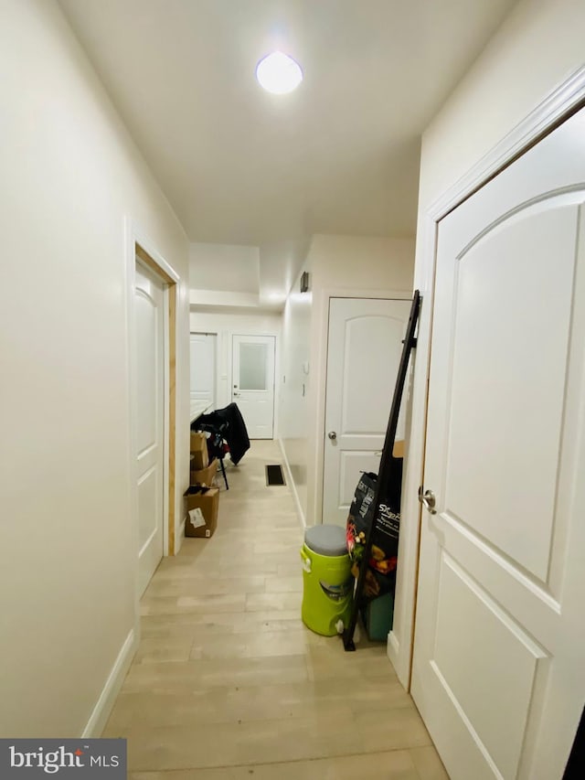hall featuring baseboards and light wood-style floors
