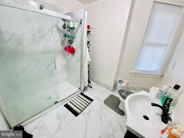 bathroom with marble finish floor, a marble finish shower, and a sink