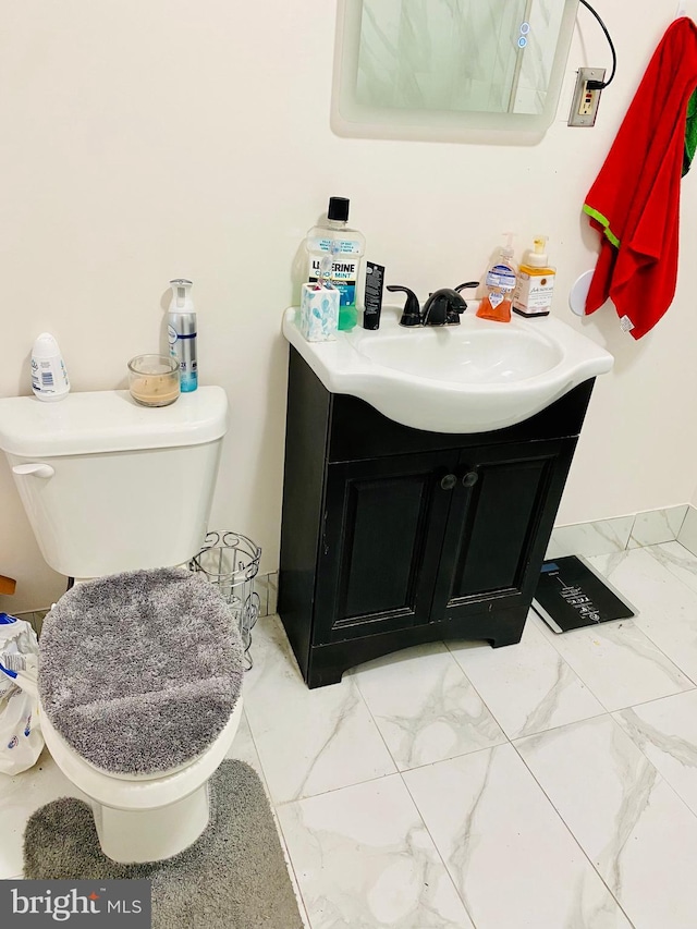 bathroom featuring marble finish floor, toilet, and vanity