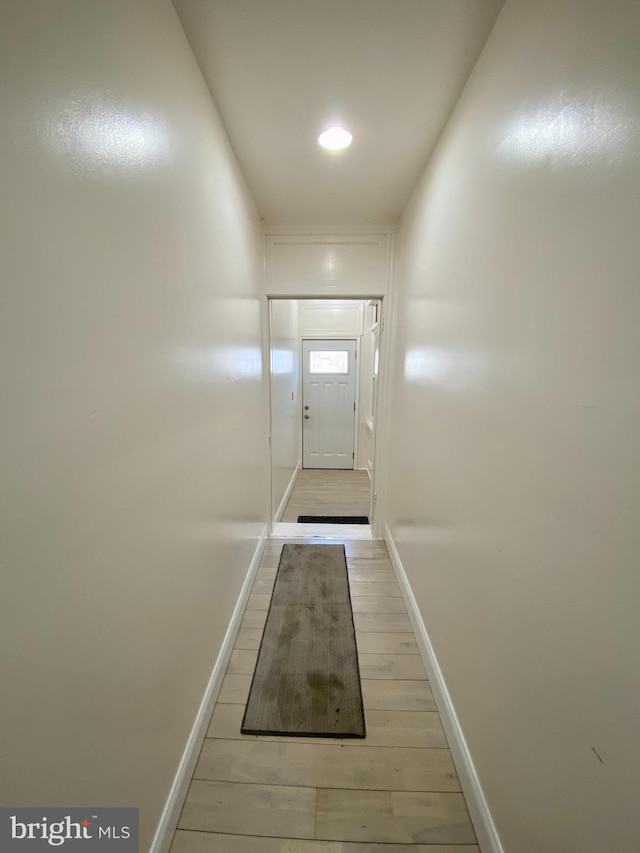 entryway with light wood-style flooring and baseboards