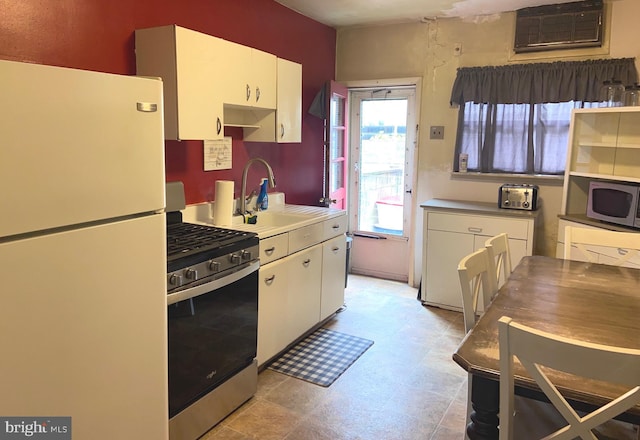 919 Dudley St, Philadelphia, PA 19148 - kitchen featuring stainless steel appliances, a sink, white cabinetry, and a wall mounted air conditioner