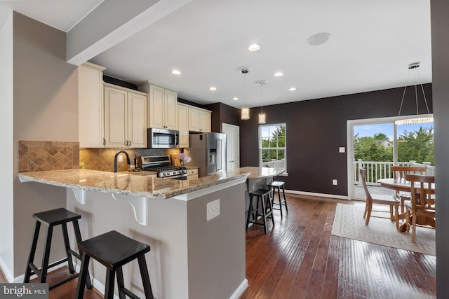 172 Trout Lily Dr, Lake Frederick, VA 22630 - kitchen featuring appliances with stainless steel finishes, light stone counters, baseboards, decorative backsplash, and a breakfast bar
