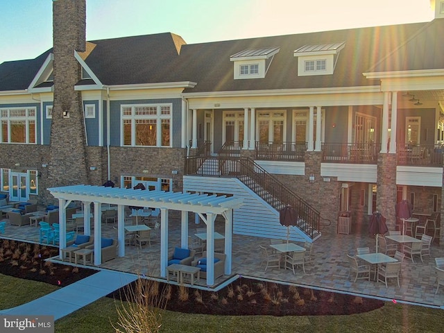 back of property with french doors, a patio area, stone siding, and stairway