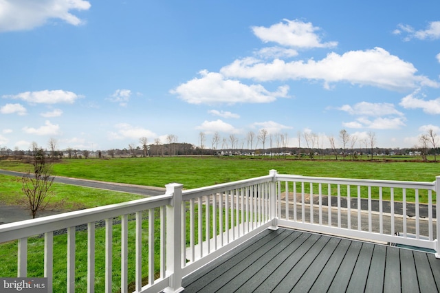 wooden deck featuring a yard and a rural view