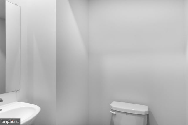 half bath featuring toilet and a sink