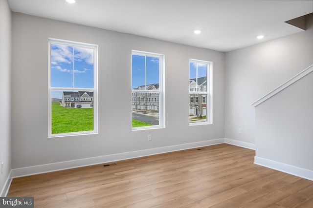 spare room with baseboards, light wood-style floors, visible vents, and recessed lighting