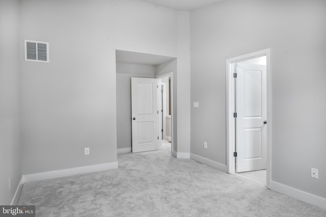 unfurnished bedroom featuring baseboards, visible vents, and carpet