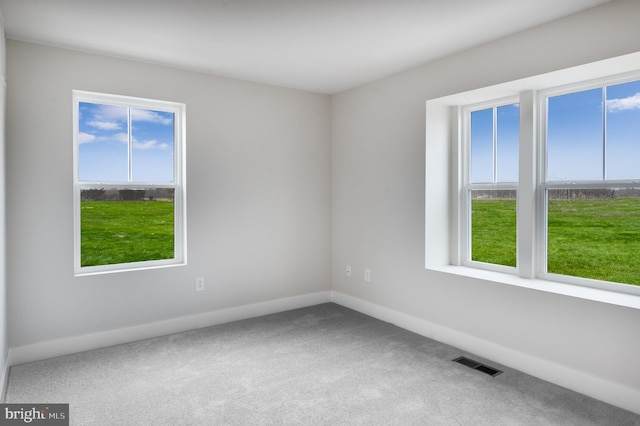 carpeted empty room with baseboards and visible vents