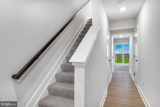 stairway with baseboards and wood finished floors