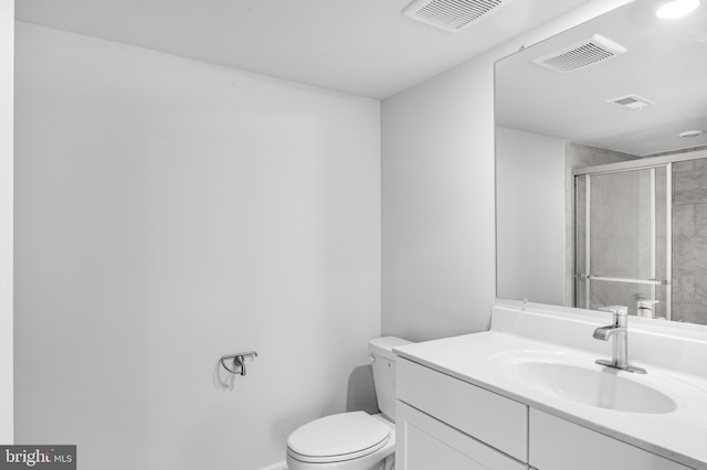 bathroom with visible vents, toilet, a stall shower, and vanity