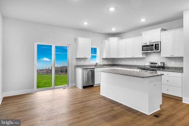 kitchen with a sink, stainless steel appliances, white cabinetry, visible vents, and recessed lighting