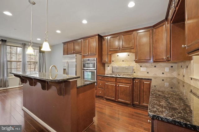 1539 Rabbit Hollow Pl, Silver Spring, MD 20906 - kitchen featuring appliances with stainless steel finishes, dark wood-type flooring, a breakfast bar, backsplash, and recessed lighting