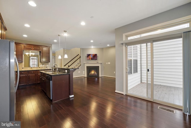 1539 Rabbit Hollow Pl, Silver Spring, MD 20906 - kitchen with appliances with stainless steel finishes, a sink, open floor plan, a lit fireplace, and plenty of natural light