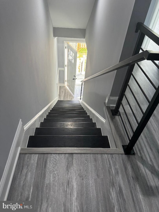 stairs featuring wood finished floors and baseboards