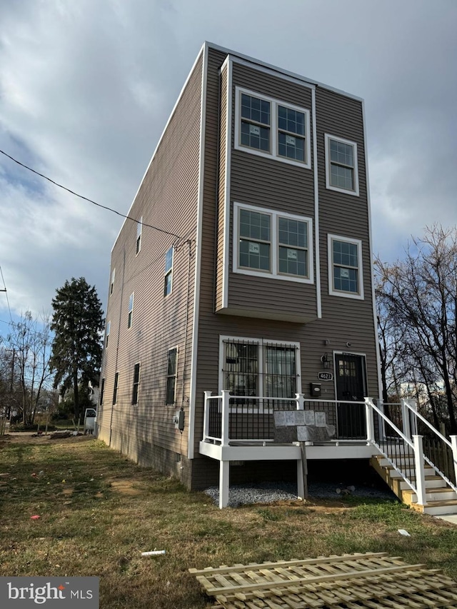 rear view of property featuring a wooden deck