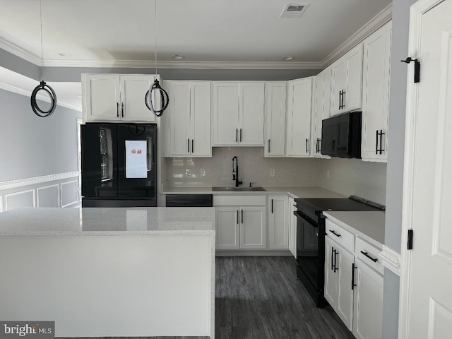 kitchen with black appliances, a sink, ornamental molding, white cabinetry, and pendant lighting