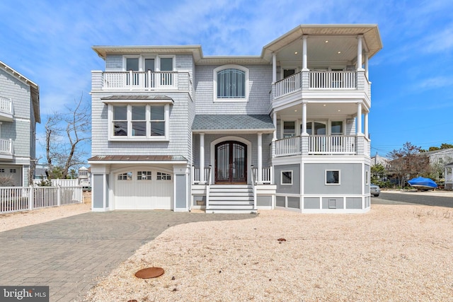 view of front of home with a garage, fence, a balcony, and decorative driveway