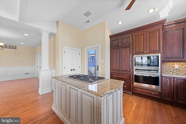 kitchen with light wood-type flooring, visible vents, stainless steel appliances, and ornate columns