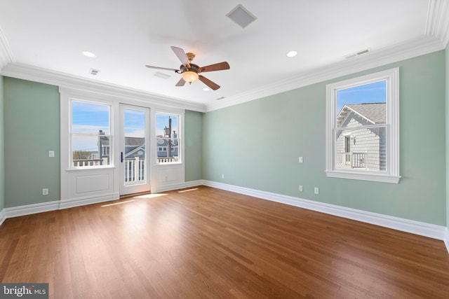 empty room with ceiling fan, wood finished floors, and plenty of natural light