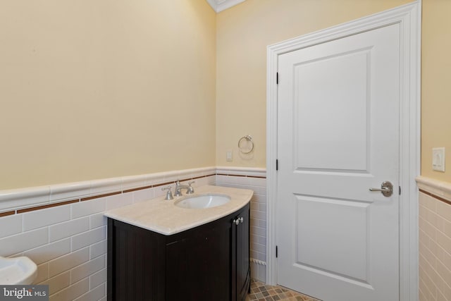 bathroom with tile walls, wainscoting, and vanity