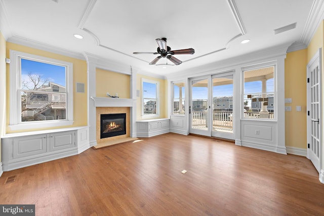 unfurnished living room with ornamental molding, visible vents, ceiling fan, and a healthy amount of sunlight