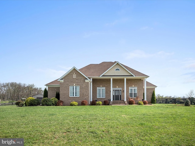 view of front of property featuring brick siding, a front lawn, and fence