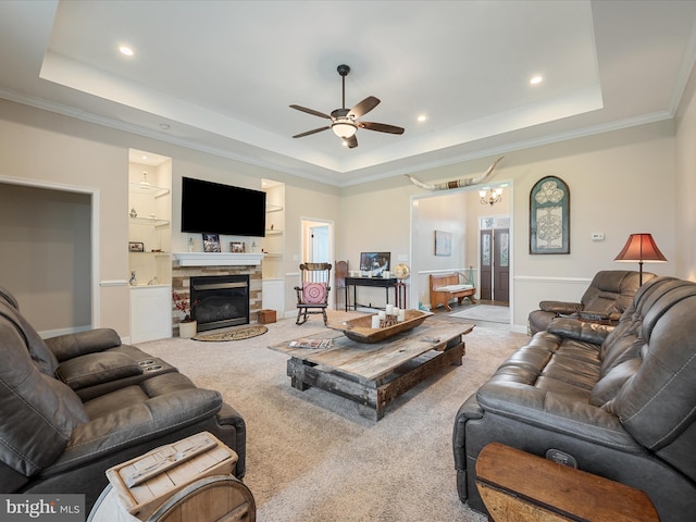 carpeted living area featuring recessed lighting, crown molding, a tray ceiling, and ceiling fan with notable chandelier