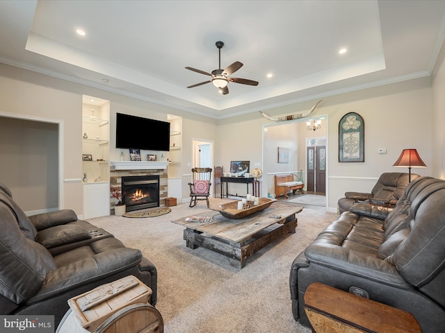 living area featuring a tray ceiling, carpet, recessed lighting, and ceiling fan with notable chandelier