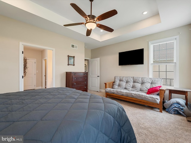 carpeted bedroom with recessed lighting, visible vents, ceiling fan, and a tray ceiling