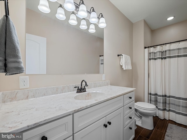 bathroom with curtained shower, wood tiled floor, an inviting chandelier, toilet, and vanity