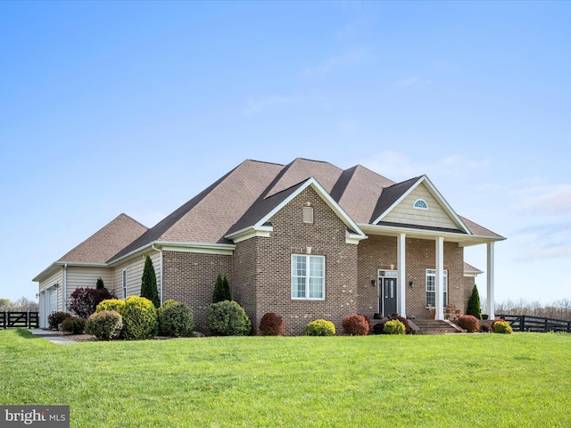 view of front of home with fence, roof with shingles, an attached garage, brick siding, and a front yard