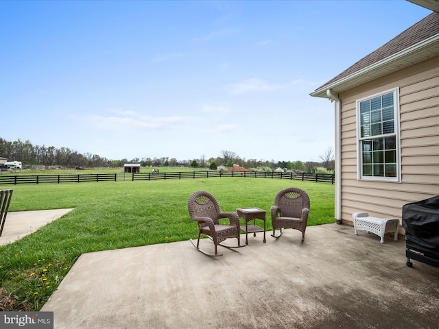view of patio with fence and a rural view