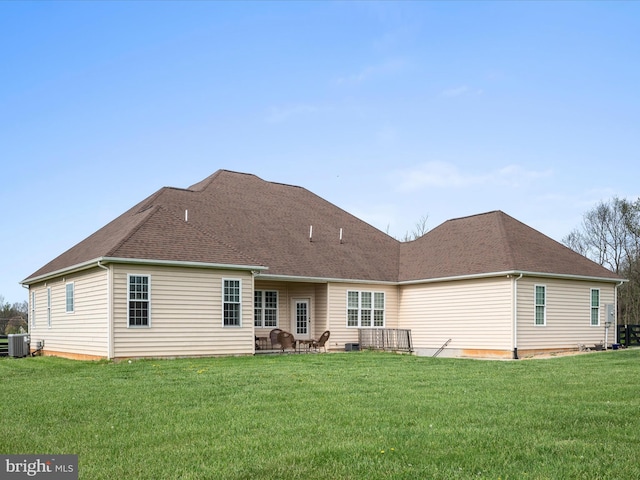 back of property with central air condition unit, a patio, and a lawn