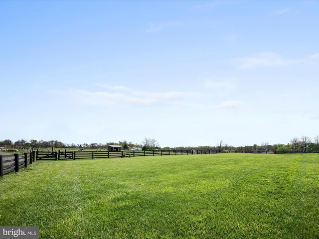 view of yard featuring fence and a rural view