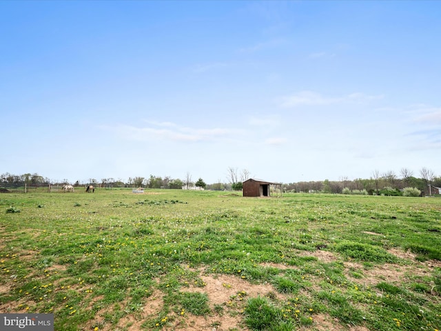 view of yard with an outbuilding, a rural view, and a barn