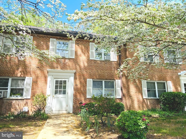 townhome / multi-family property with brick siding and cooling unit
