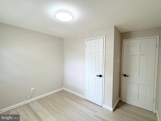 unfurnished bedroom with light wood-style floors and baseboards