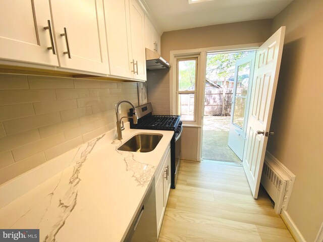 kitchen featuring white cabinets, stainless steel appliances, visible vents, backsplash, and under cabinet range hood