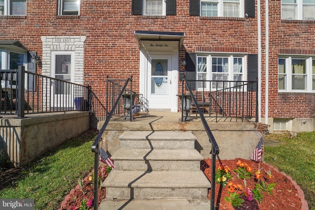 doorway to property featuring brick siding