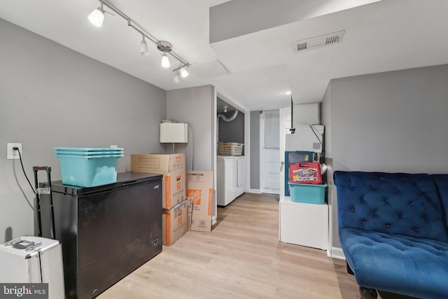 interior space with visible vents, refrigerator, separate washer and dryer, and light wood-style flooring