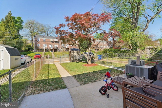 view of yard with an outbuilding, a shed, and a fenced backyard