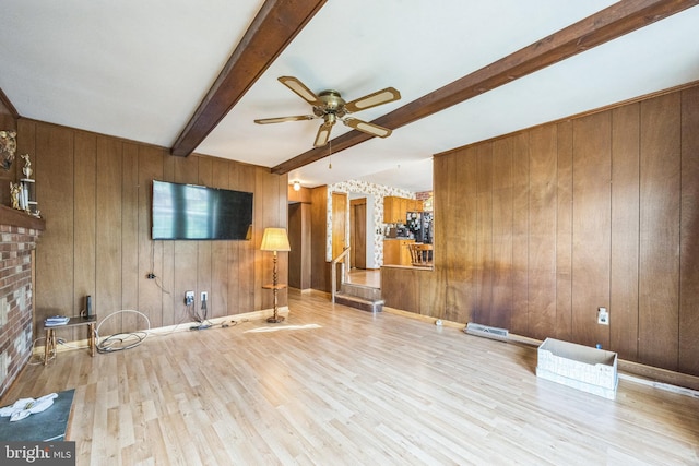 unfurnished living room featuring beamed ceiling, a ceiling fan, wood finished floors, wooden walls, and a fireplace
